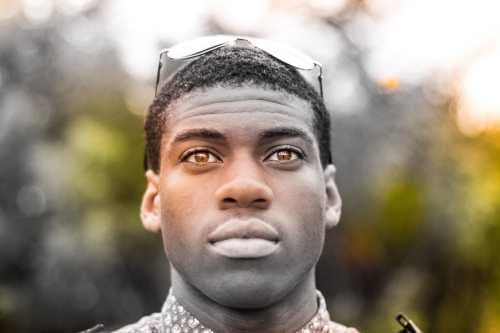 Black man wearing glasses on his head and looking up